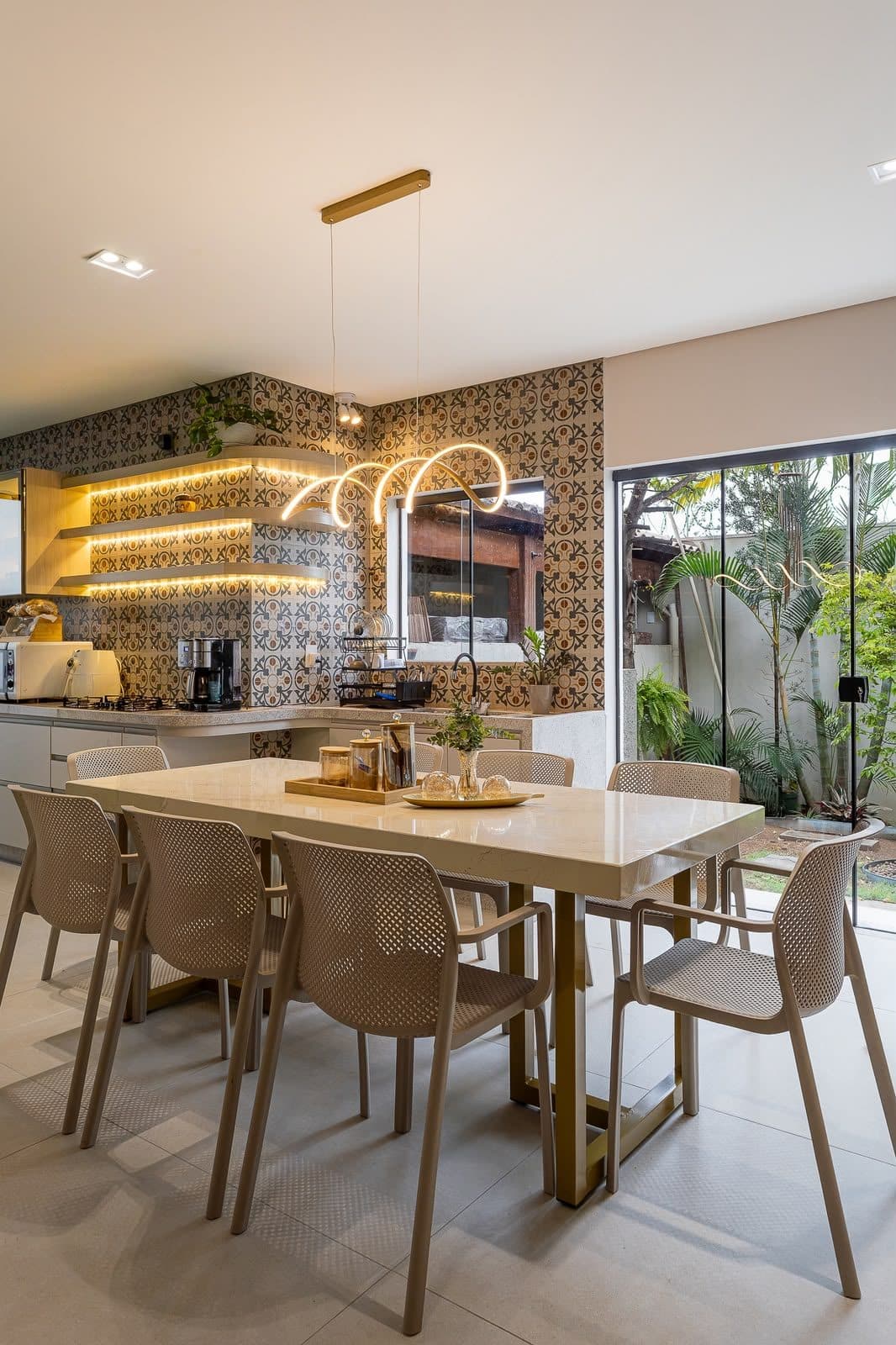 Cozinha planejada com azulejos artesanais em tons terrosos, iluminação indireta em nichos e bancadas claras